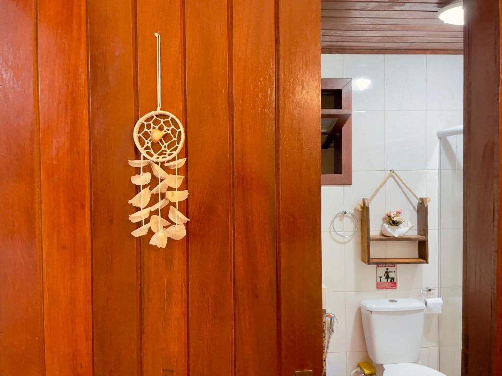 baño con aseo y pared de madera en Casa Barracuda, en Búzios
