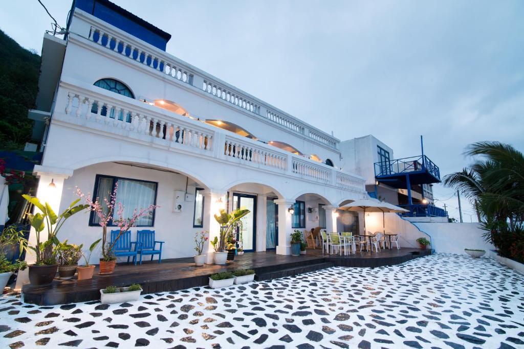 un gran edificio blanco con un patio enfrente en Shengtuolini B&B en Yanliau