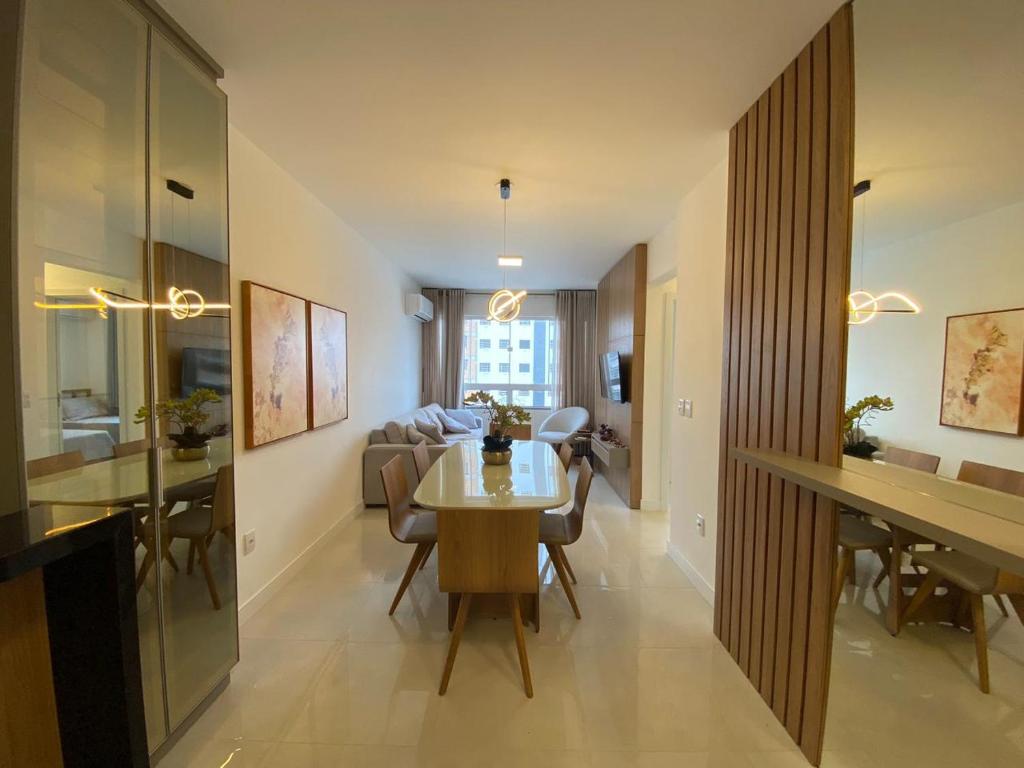 ein Esszimmer und ein Wohnzimmer mit Tisch und Stühlen in der Unterkunft Apartamento Condado San Isidoro in Capão da Canoa