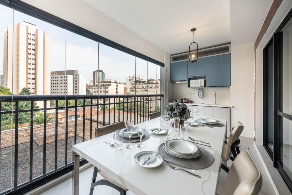 a dining room with a white table and a balcony at Rosemari's Apartments 22 Apartamento Luxuoso in Sao Paulo
