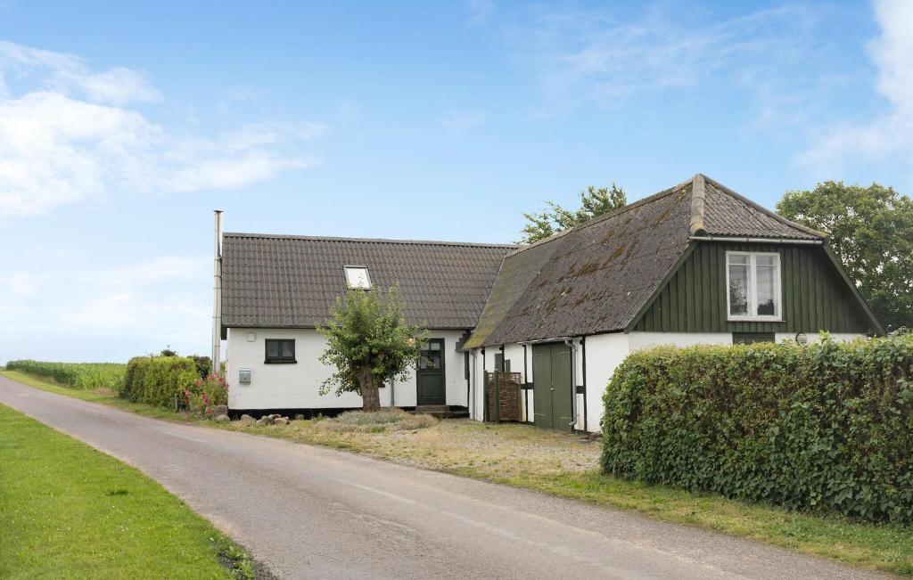 a white house with a black roof and a road at 1 Bedroom Amazing Home In Stubbekøbing in Stubbekøbing