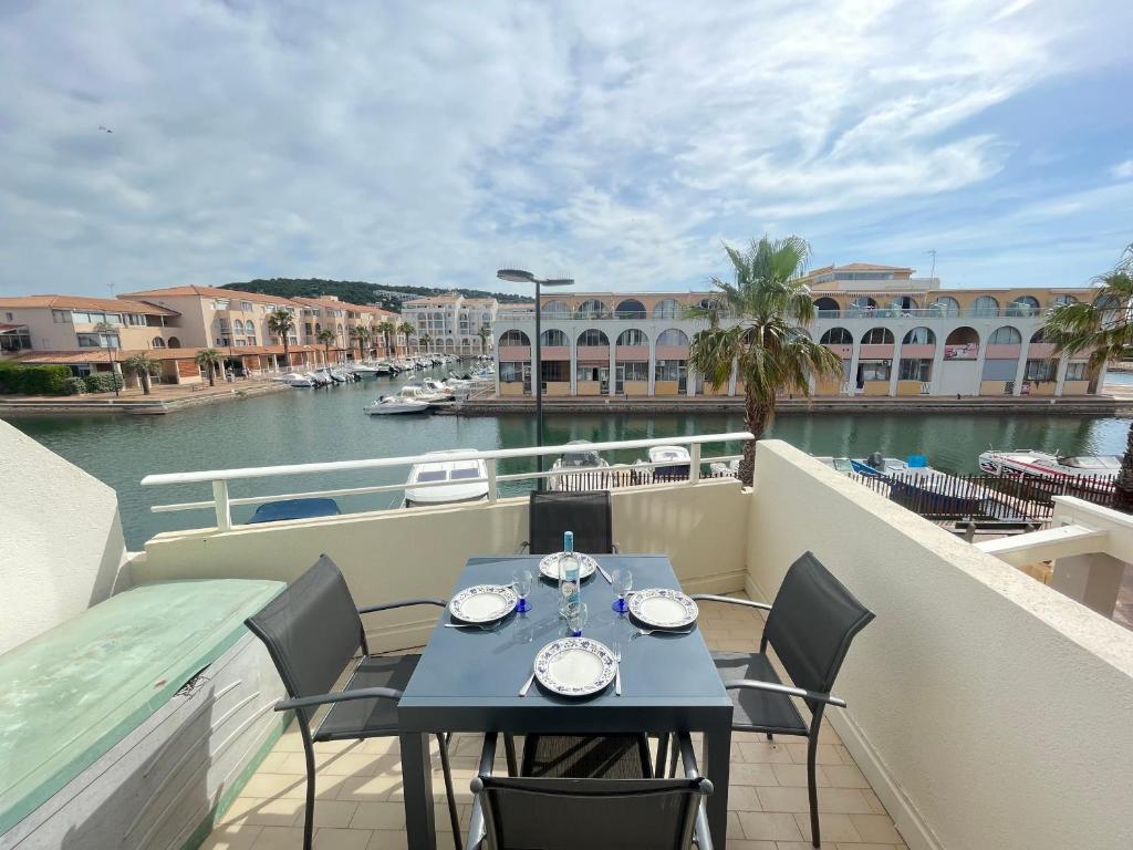 - une table sur un balcon avec vue sur la rivière dans l'établissement T2 avec loggia vitrée, terrasse, parking à Sète - FR-1-338-589, à Sète