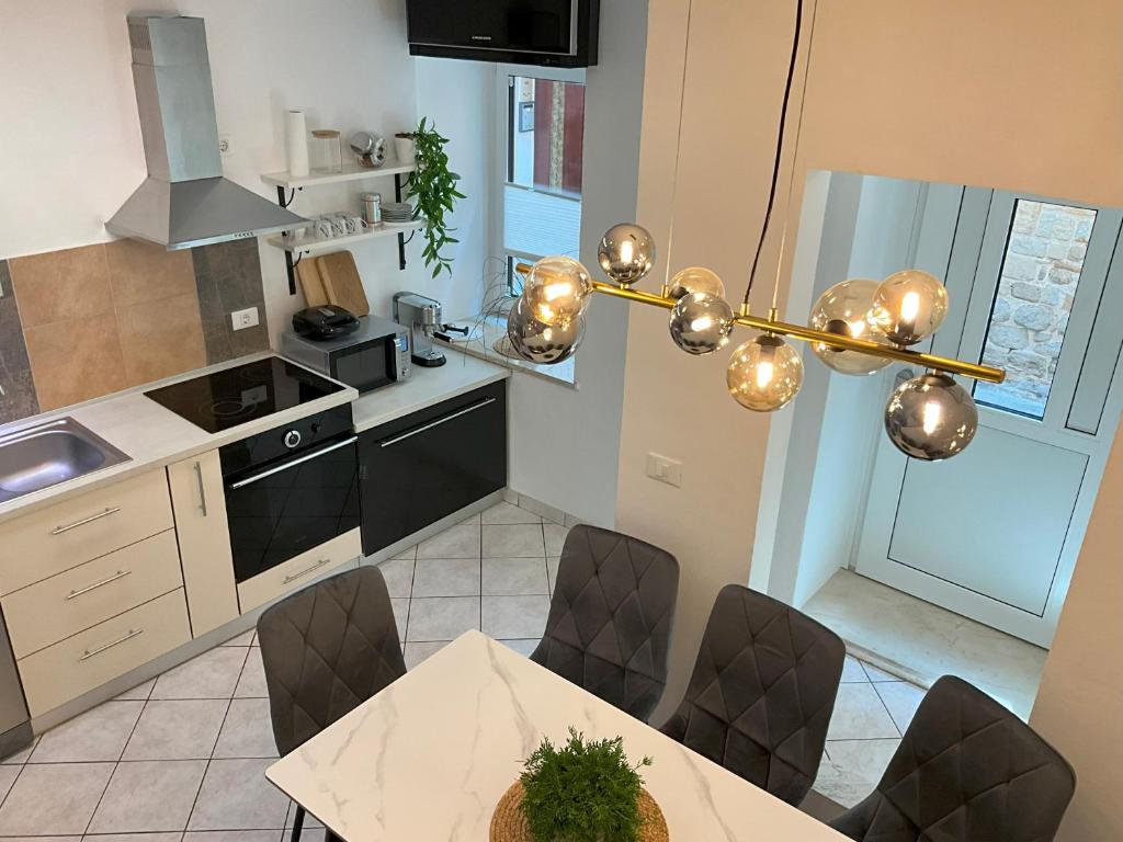 a kitchen with a table and chairs and a chandelier at Emica's holiday home in Koper