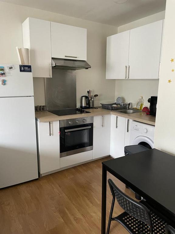 une cuisine avec des armoires blanches et un comptoir noir dans l'établissement Solférino, à Lille