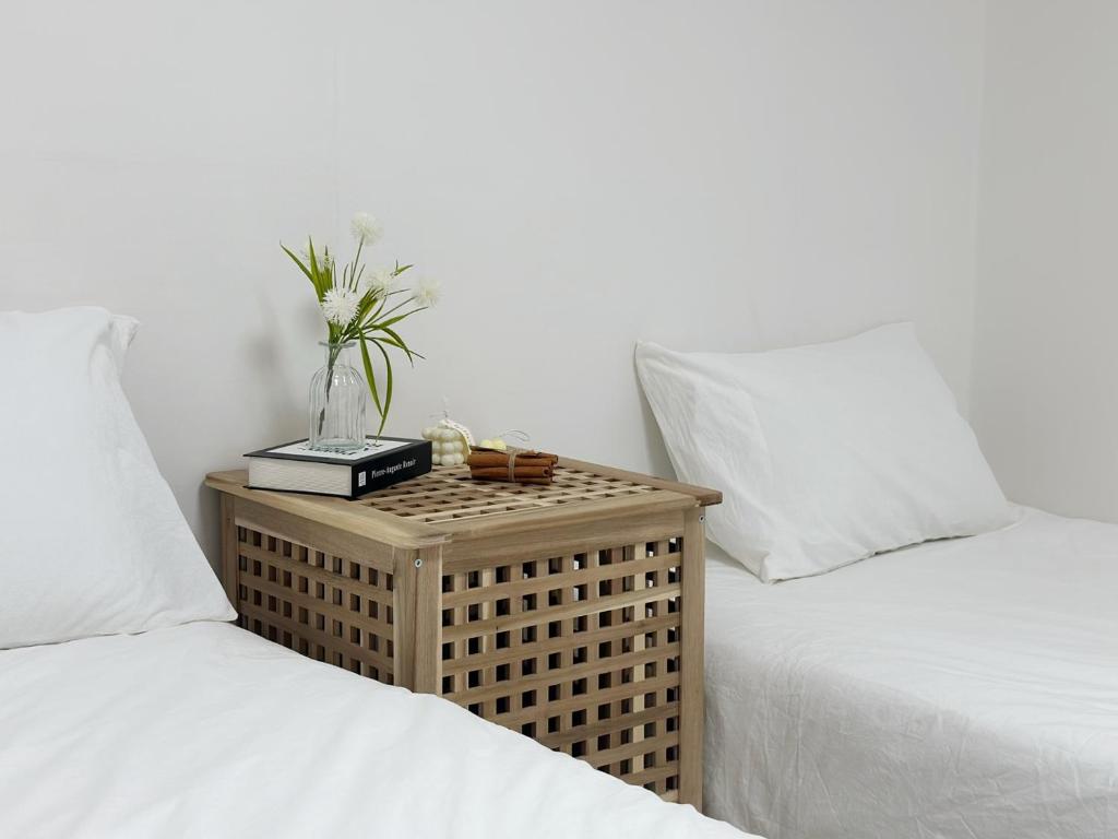 two beds with white sheets and a table with a plant at Jamsil Seokchon-dong #Lotteworld #Seokchonlake #Lottetower #KSPO DOME #stadium in Seoul