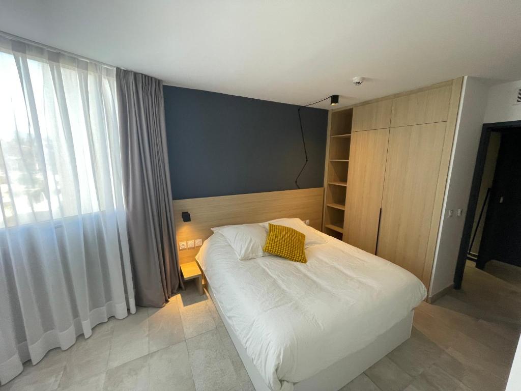 - une chambre avec un lit doté d'un oreiller jaune dans l'établissement Maougavi T2 Bloom Le Spot, à La Ciotat
