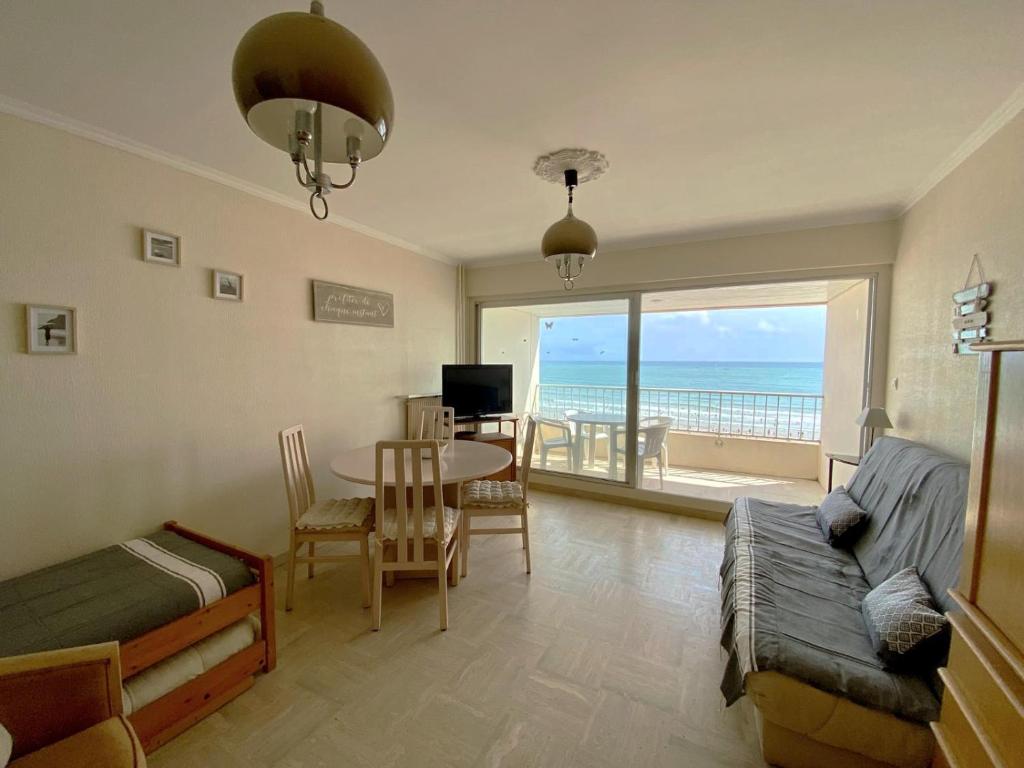 - un salon avec un lit et une table offrant une vue sur l'océan dans l'établissement Le Petit Foch - Face a la plage, à Les Sables-dʼOlonne