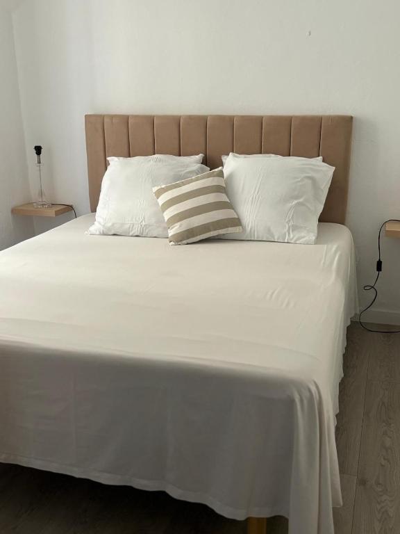 Elle comprend un grand lit avec des draps et des oreillers blancs. dans l'établissement Appartement centre ville cannes, à Cannes
