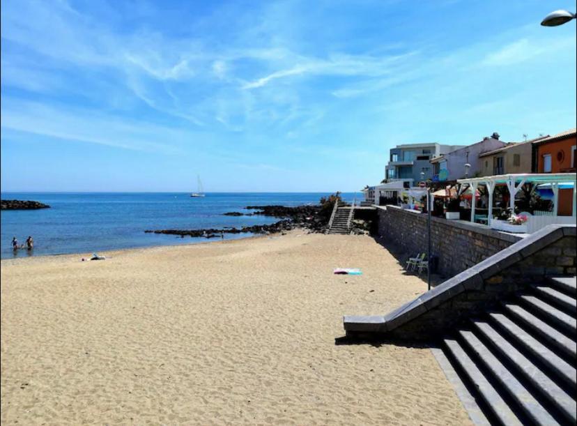 une plage avec des escaliers et l'océan et un bâtiment dans l'établissement Studio charmant Cap d'Agde, au Cap d'Agde