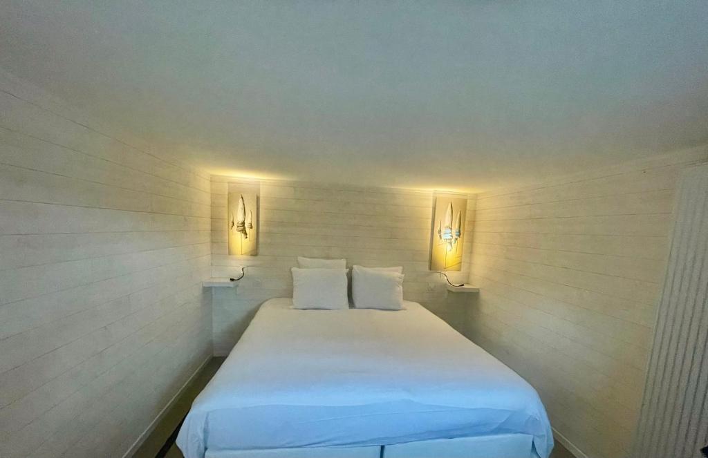 a white bed in a room with two lights at dday cottage gold beach in Saint-Côme-de-Fresné