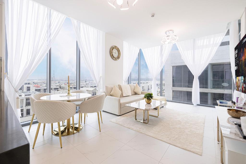 Hotel Luxury Apt Burj Khalifa, Sunset and Lagoon view, a living room with white furniture and large windows at Luxury Apt Burj Khalifa, Sunset and Lagoon view in Dubai