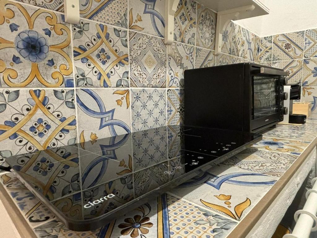 una televisione su un bancone in una stanza con piastrelle di Dimora Ennui Ostuni a Ostuni