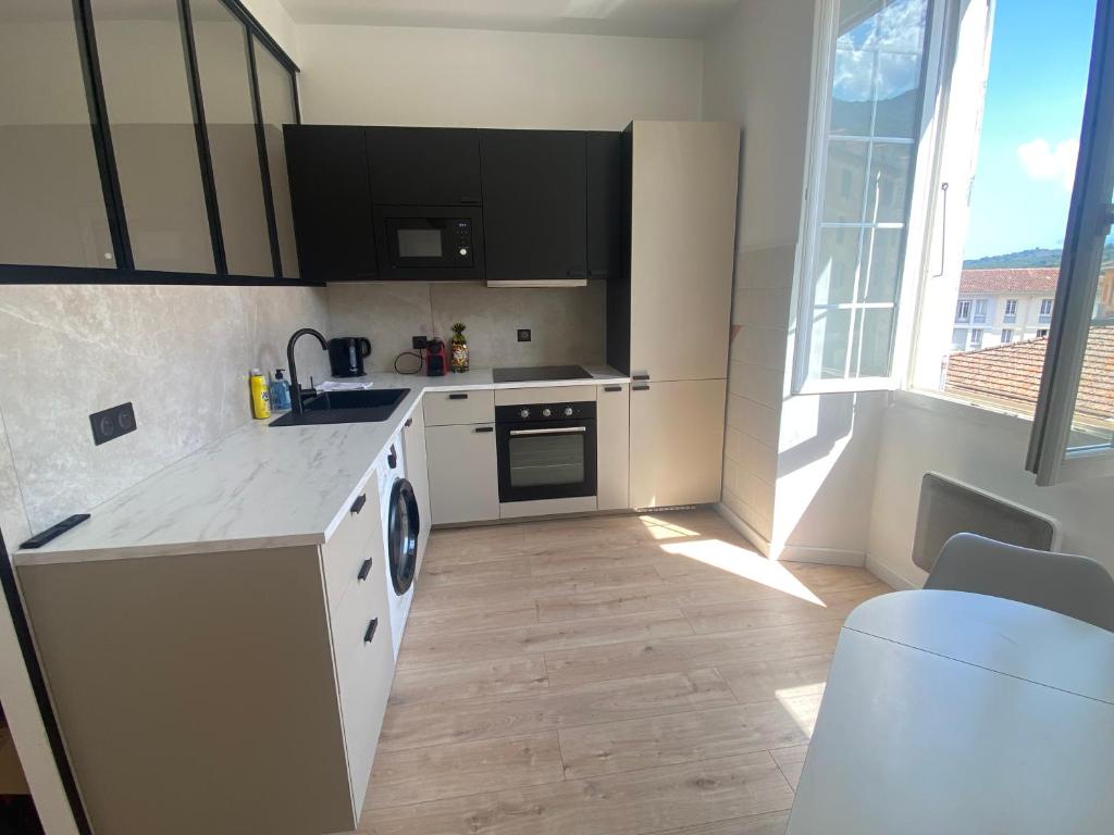 une cuisine avec un évier et un lave-vaisselle dans l'établissement Joli studio en centre-ville, à Corte