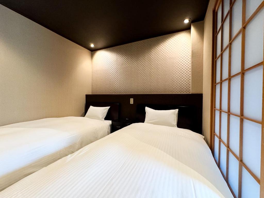Postel nebo postele na pokoji v ubytování Rinn Hostel Miyagawacho