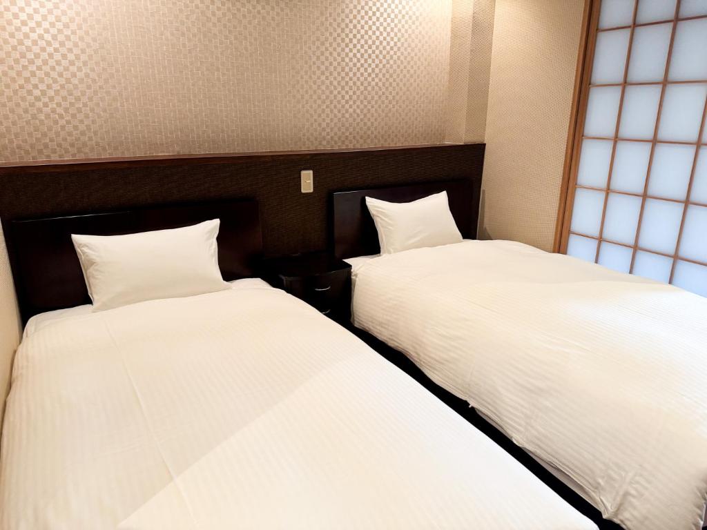 Postel nebo postele na pokoji v ubytování Rinn Hostel Miyagawacho