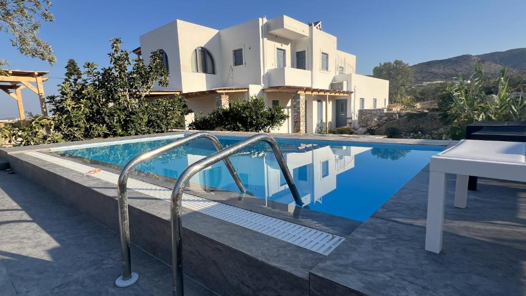 a villa with a swimming pool in front of a house at La maison in Parikia