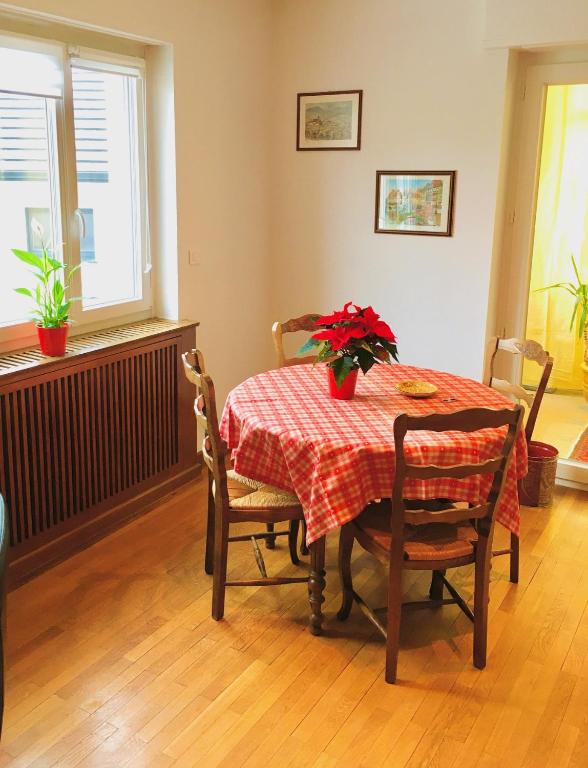 - une table à manger avec une nappe rouge et des fleurs dans l'établissement Gîte City Relax, entre nature et centre-ville, à Colmar