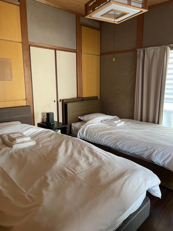 Postel nebo postele na pokoji v ubytování LAZYHOUSE 別邸