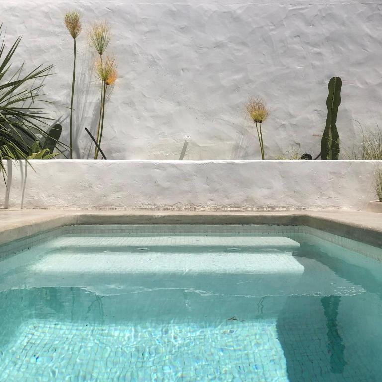 a swimming pool with blue water in a backyard at Casa Sul - Casas de Seixe in Baiana