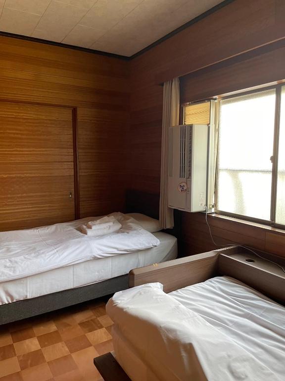 Postel nebo postele na pokoji v ubytování LAZYHOUSE 別邸