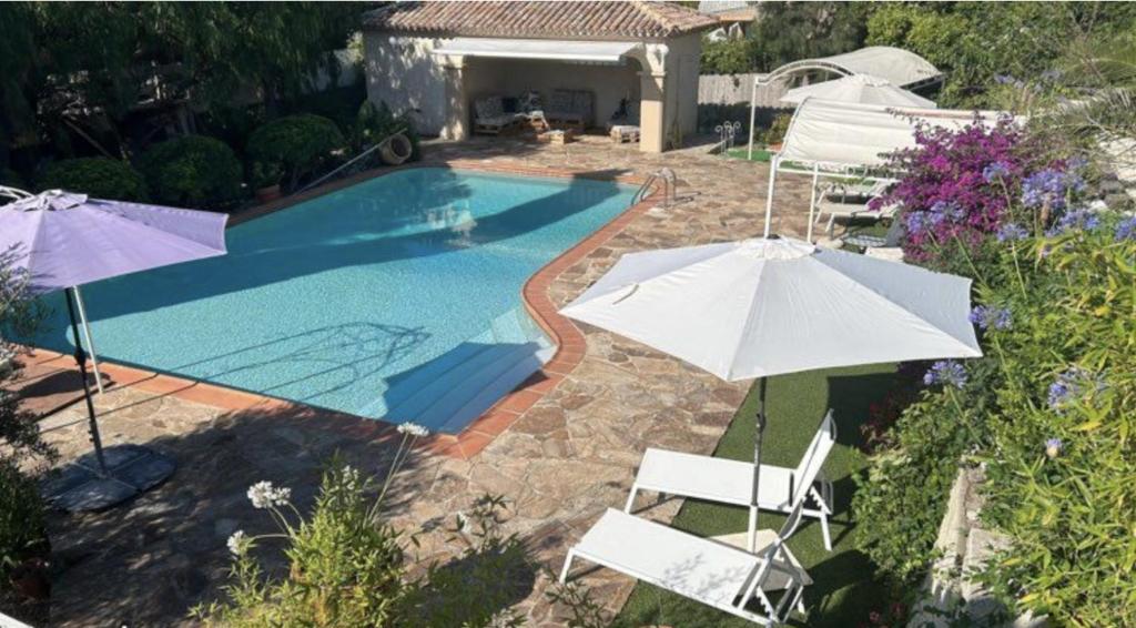 - une piscine avec 2 parasols et 2 chaises dans l'établissement Appartement 4 pers avec terrasse et piscine, à Bormes-les-Mimosas