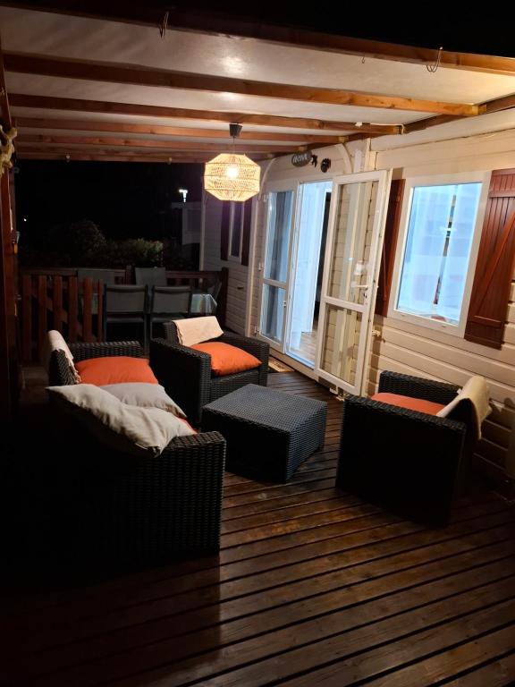 - un salon avec des canapés et des chaises sur une terrasse dans l'établissement Mobilhome paisible et verdoyant, à Puget-sur Argens