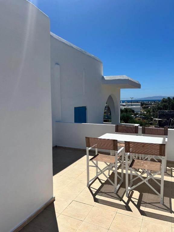 a white table and chairs on the roof of a house at Olive House in Márpissa