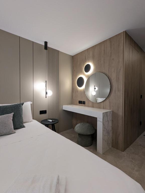 a bedroom with a white bed and a mirror at Tuck Inn in Larnaca