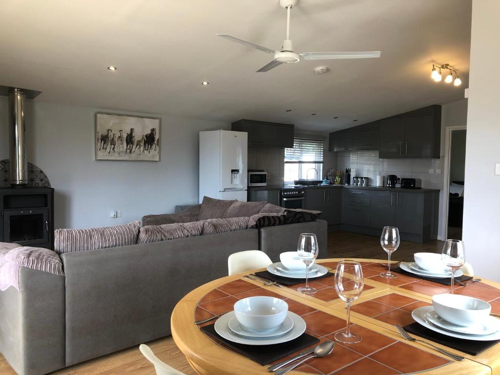 a living room with a couch and a table with wine glasses at Nightingale Lodge - Adults Only in Lackford