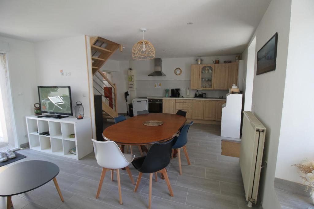 une cuisine et une salle à manger avec une table et des chaises dans l'établissement Maison de famille 8 personnes, à Étel