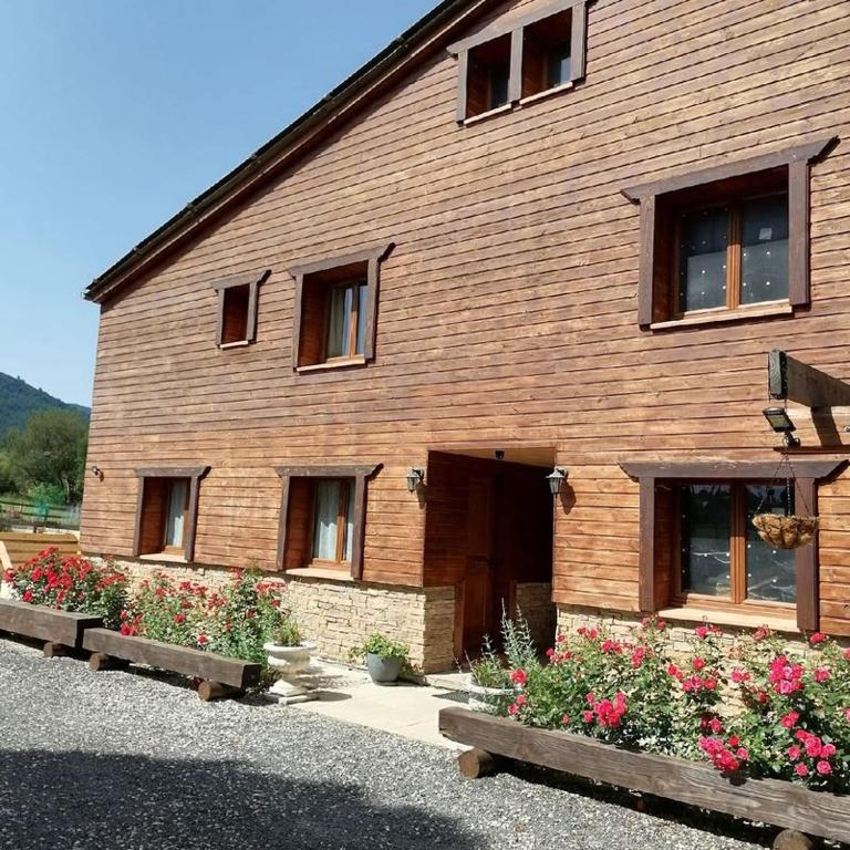 un bâtiment en bois avec des fleurs devant lui dans l'établissement Chalet 