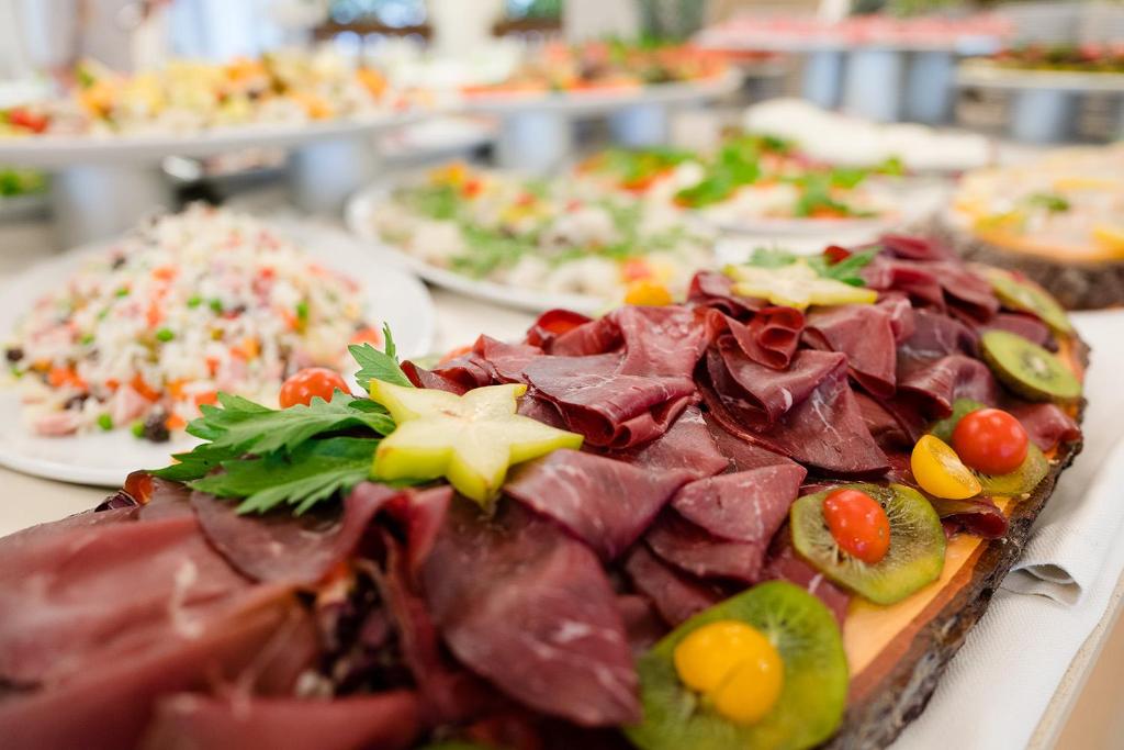 a table with many plates of food on it at Laguna Park Hotel 4Superior in Bibione