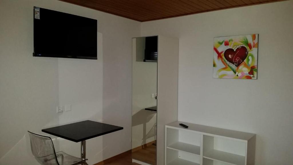 una camera con tavolo e TV a parete di good bed biberist a Biberist