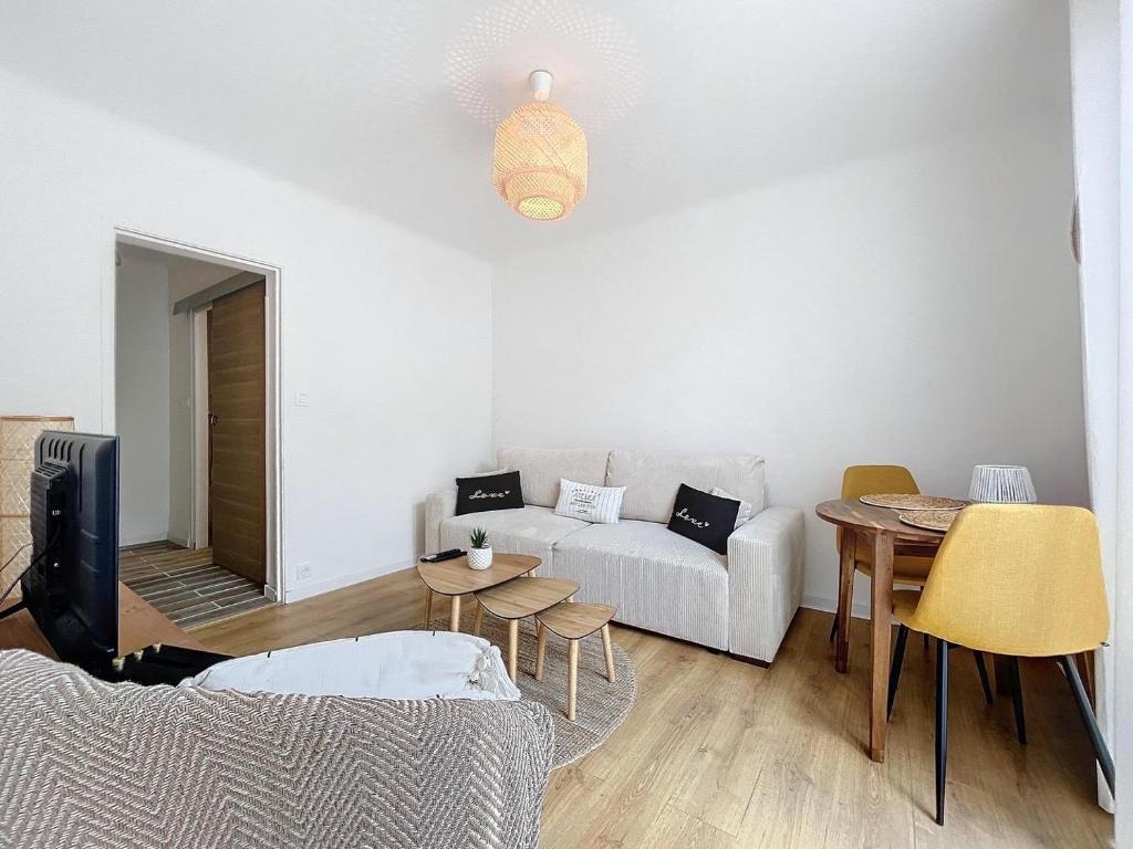 a living room with a couch and a table at La petite boétie in Sarlat-la-Canéda