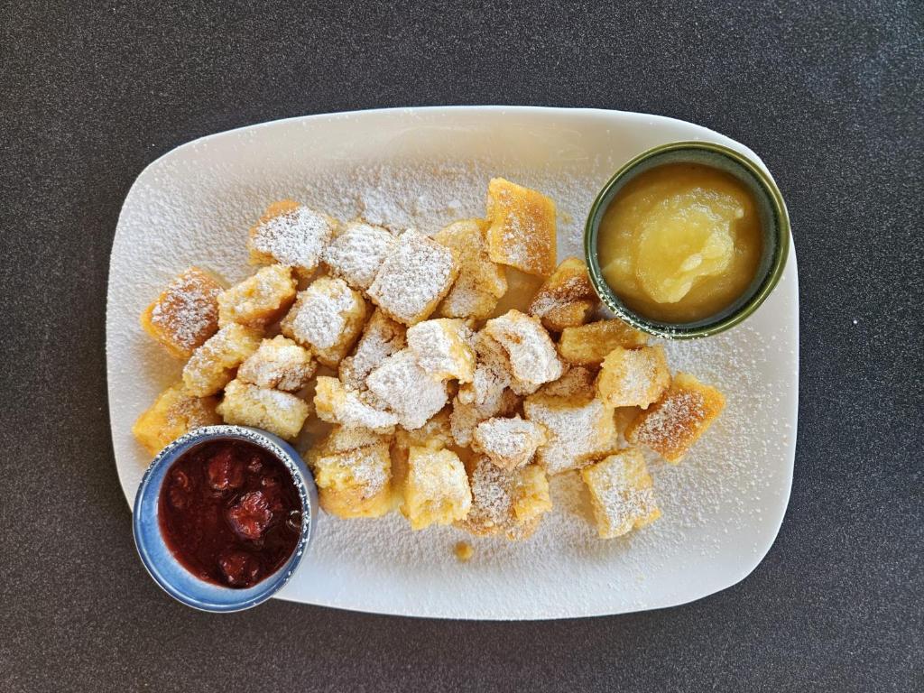 a plate of food with a bowl of dipping sauce at Hotel Fuchs & Hase SELF CHECK IN in Rosegg
