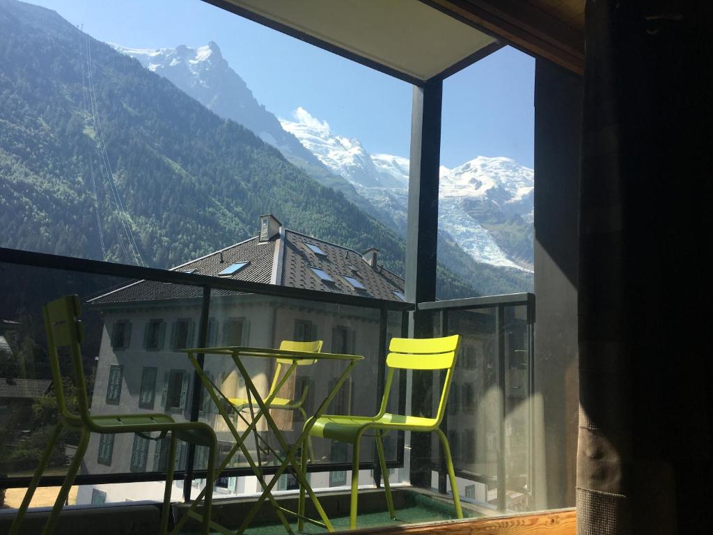 d'un balcon avec deux chaises et une vue sur les montagnes. dans l'établissement Magnifique Studio Plein centre vue panoramique, à Chamonix-Mont-Blanc