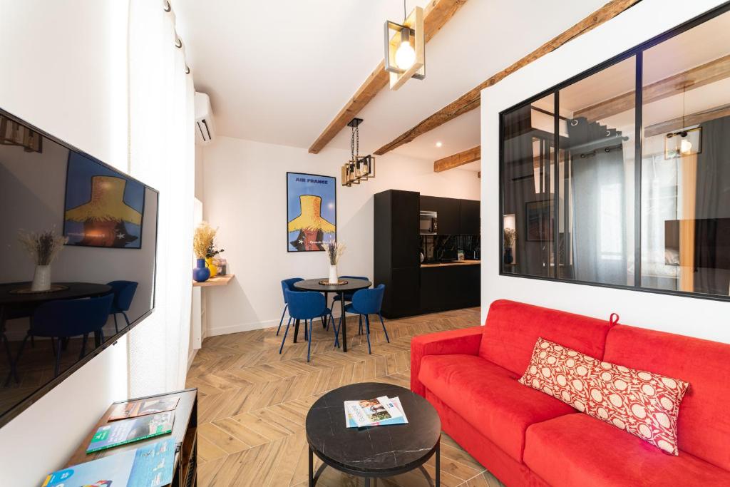un salon avec un canapé rouge et une table dans l'établissement French riviera old town heart, à Nice