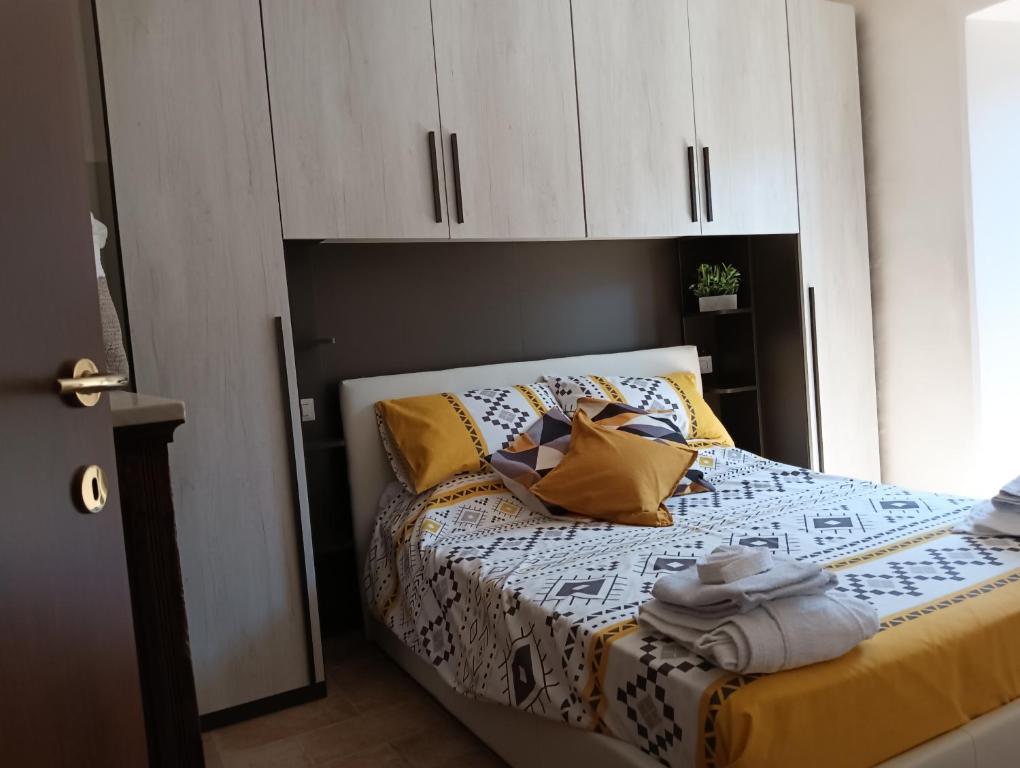 a bedroom with a bed with white cabinets and yellow pillows at La casina in Caprarola