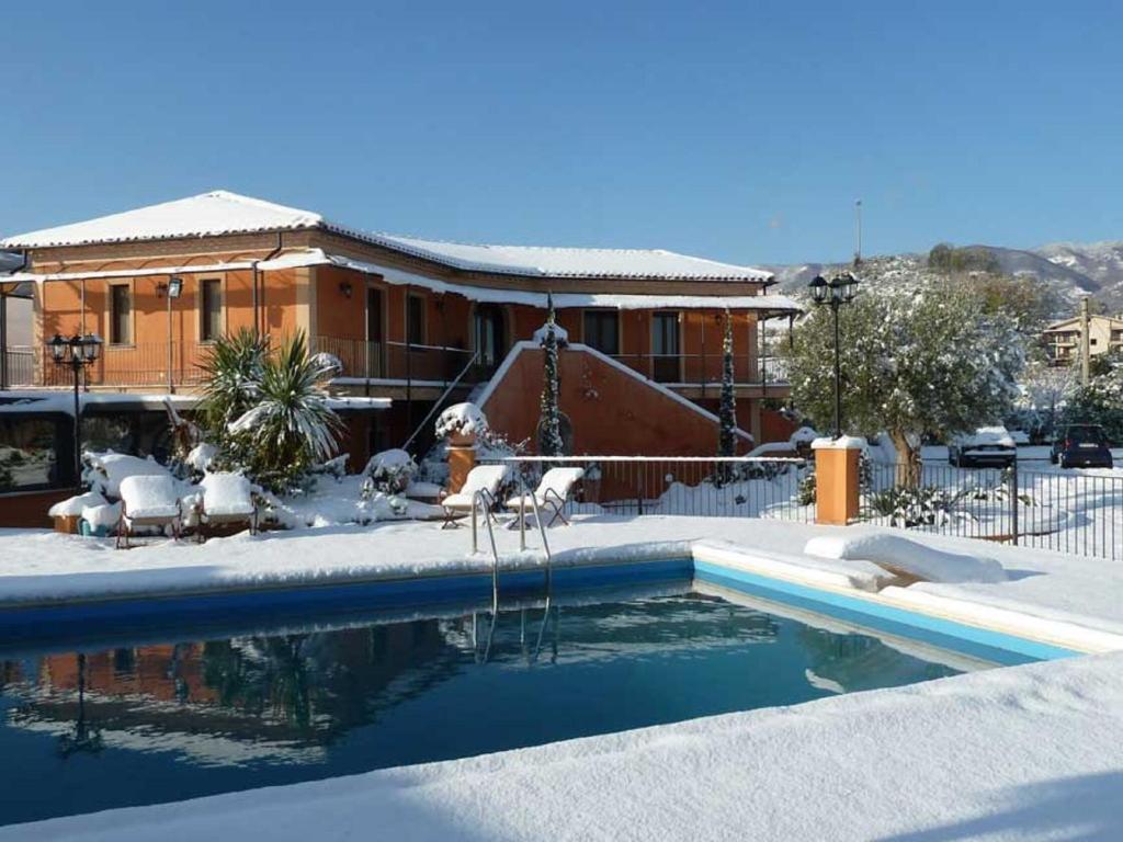 a swimming pool in front of a house at Albergo Arinde in Rende