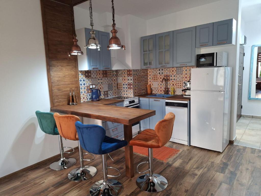 a kitchen with a wooden table and chairs and a refrigerator at Apartment Pirin in Bansko