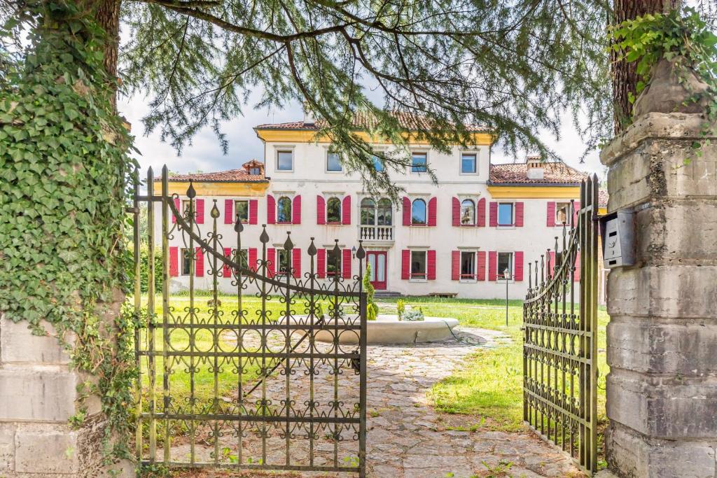 an entrance gate to a large white and pink building at Belluno Timeless Charm - Stunning Aparment in Villa in Belluno