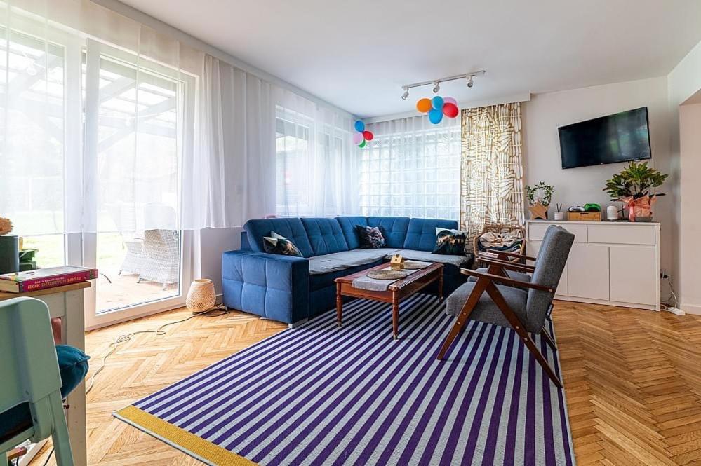 a living room with a blue couch and a table at DOM 4 SEZONY in Osłonin