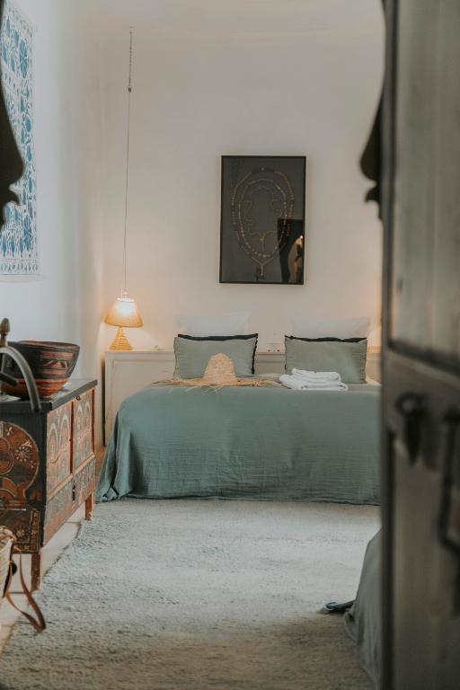 a bedroom with a bed with a green blanket at Dar El Qadi in Marrakech
