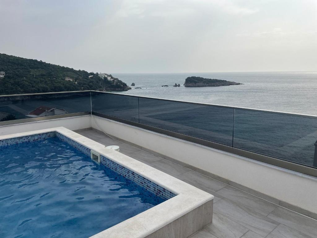 a swimming pool on top of a building with the ocean at Morski plamen in Kruče