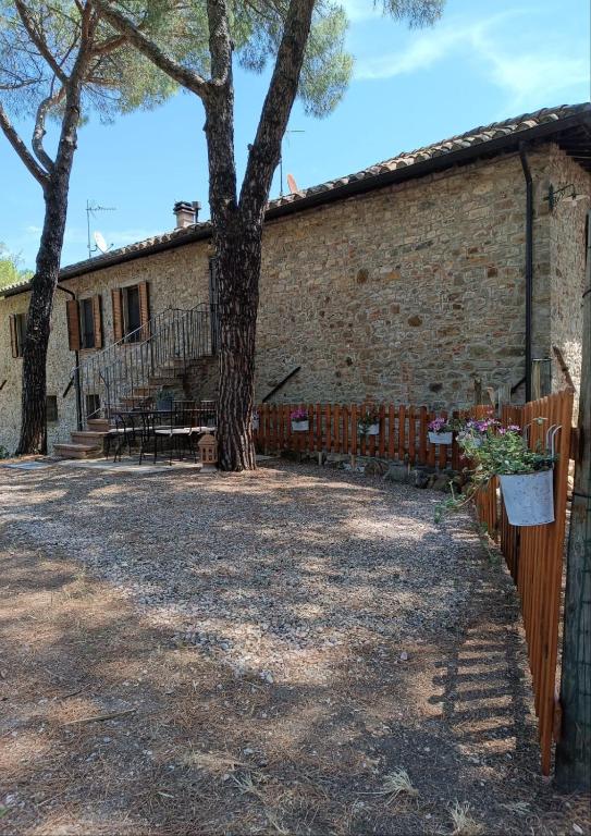 a brick building with a tree and a fence at La casa dei breton in Magione