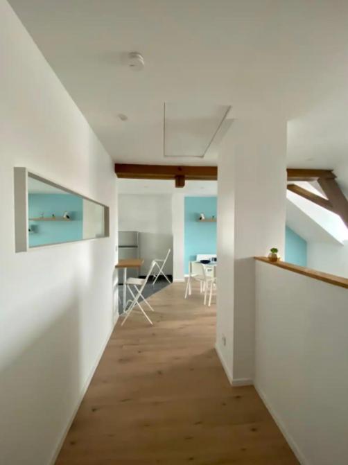 Cette chambre vide est dotée de murs blancs et de parquet. dans l'établissement Studio cosy comme à la maison, à Mulhouse