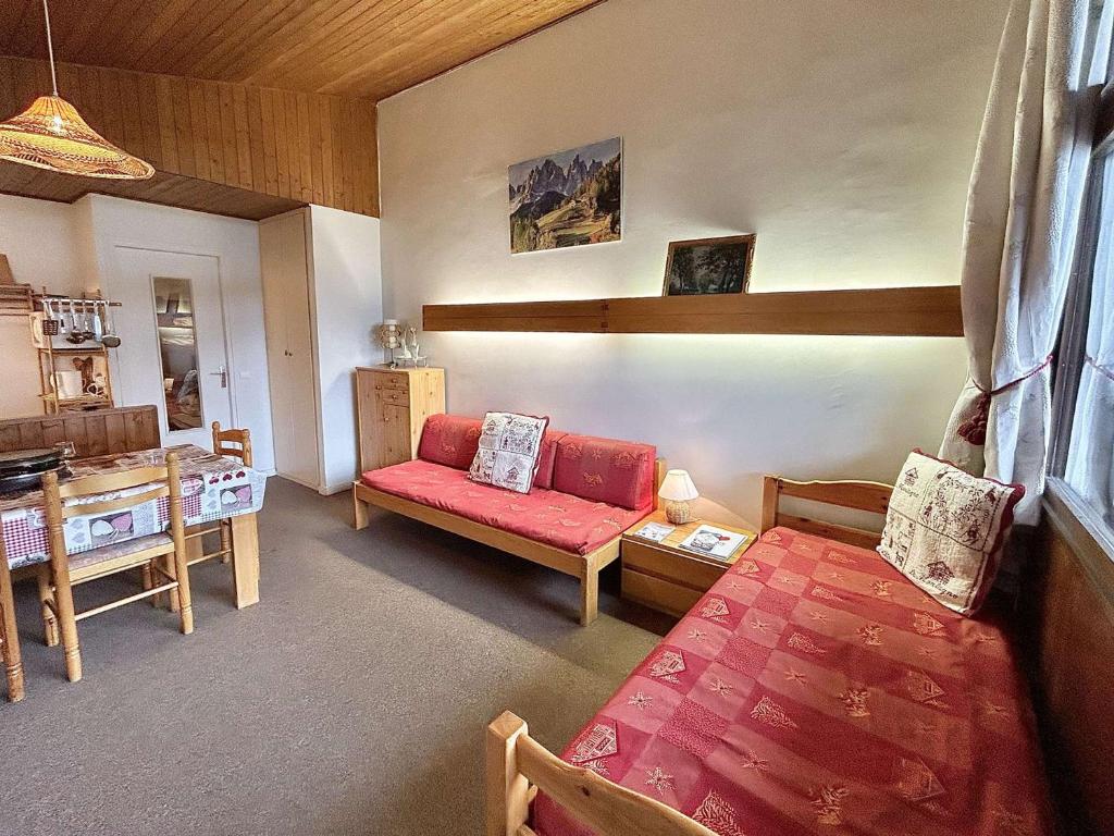 un salon avec un canapé rouge et une table dans l'établissement Appartement 2 pièces+alcôve, 4 couchages, parking, Megève - FR-1-597-27, à Megève