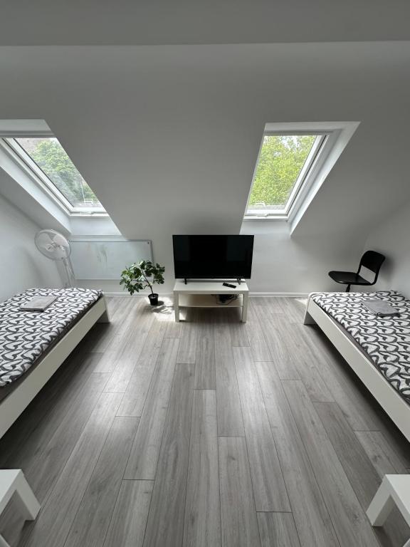 a room with two beds and a flat screen tv at Zentral gelegenes Apartment am Bunter Garten MG09 in Mönchengladbach