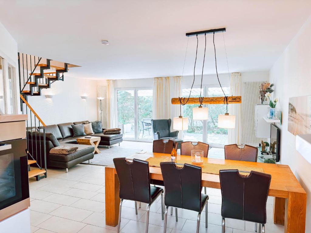 a dining room and living room with a table and chairs at Kapitänshaus Useney in Norderney