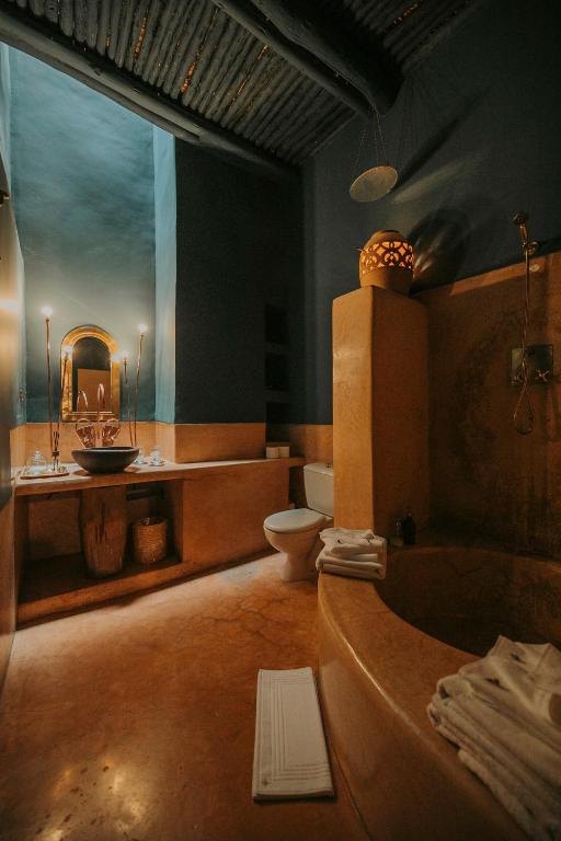 a bathroom with a tub and a sink and a toilet at Dar El Qadi in Marrakech